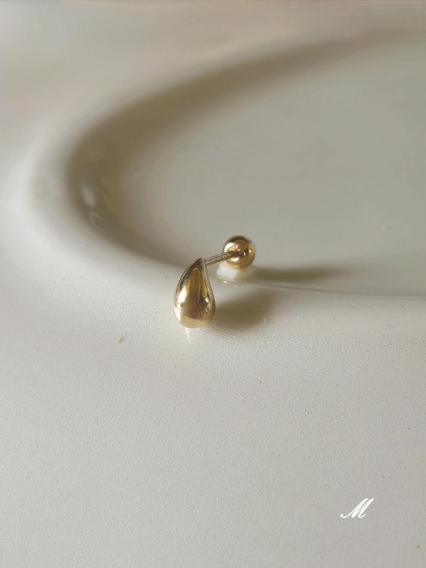 14k solid gold Teardrop screwball piercing. Teardrop piercing.