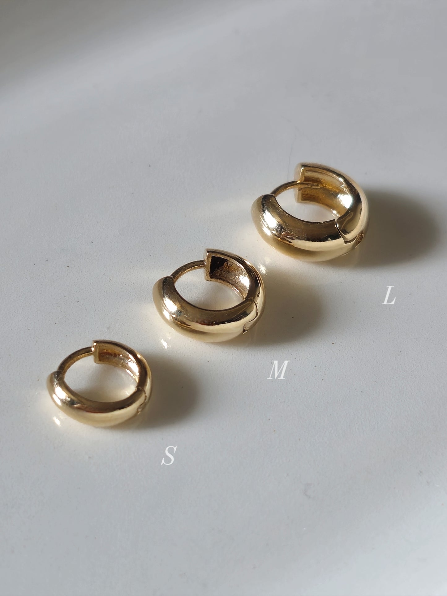 14K solid gold Snug-fitting huggie style earring  that sits close to the ear.