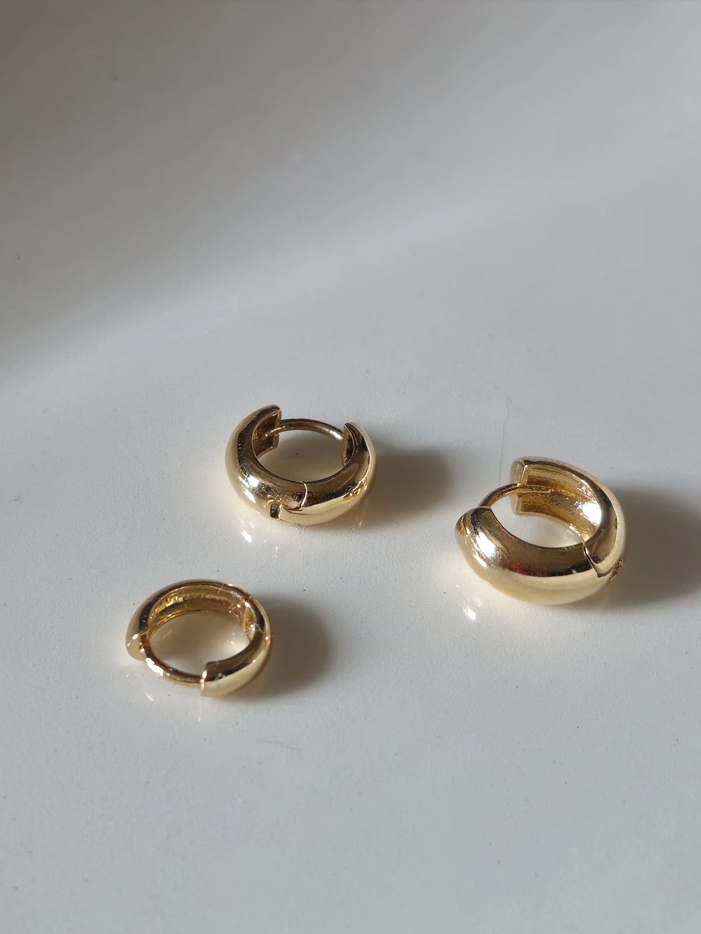 14K solid gold Snug-fitting huggie style earring  that sits close to the ear.
