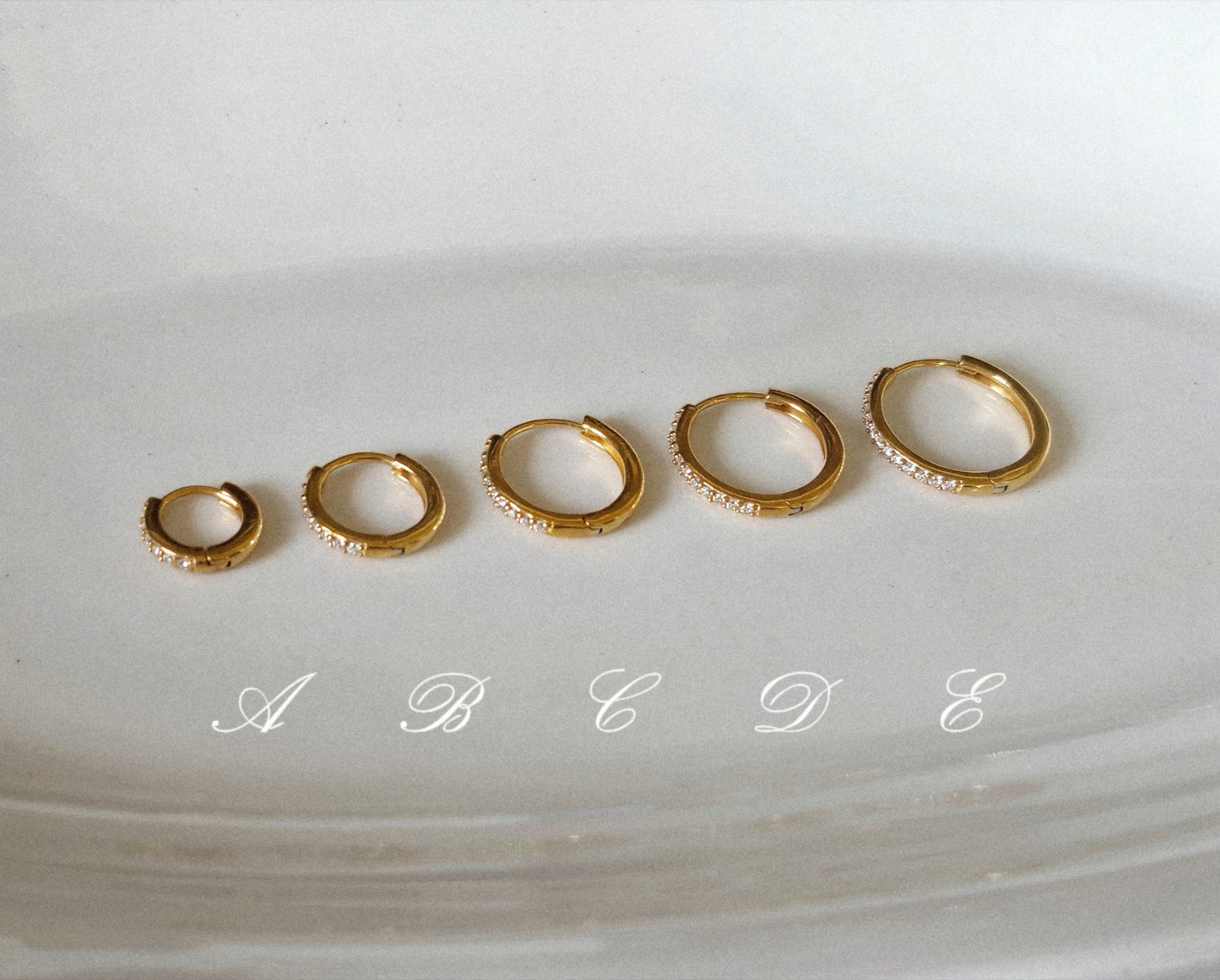 Sterling silver cubic pave hoop earrings.