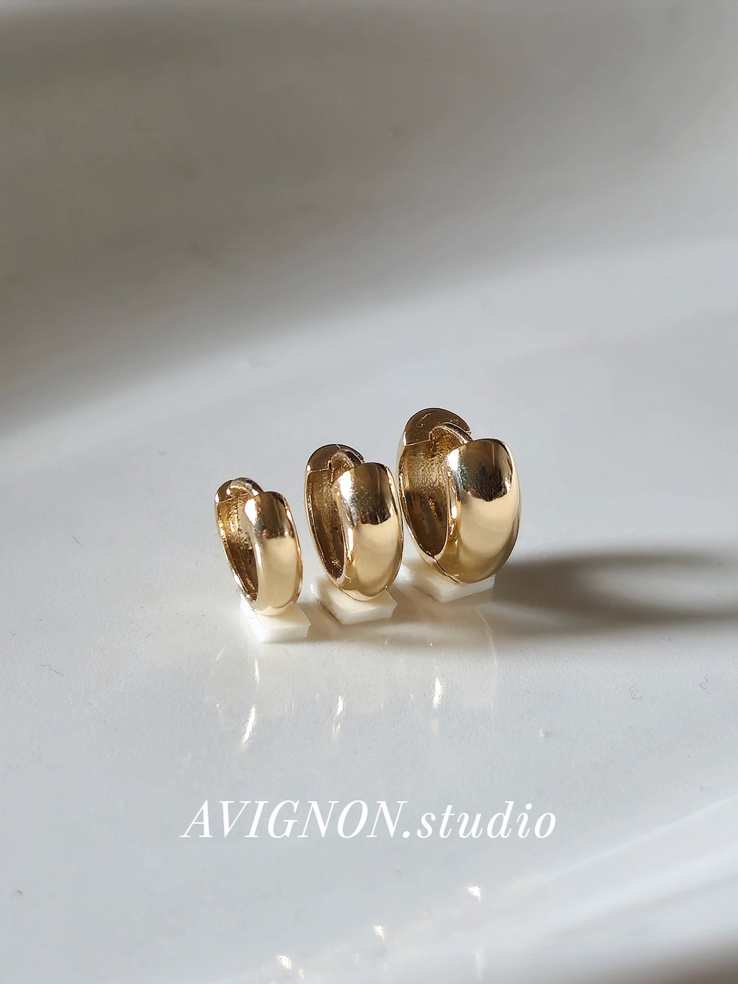 14K solid gold Snug-fitting huggie style earring  that sits close to the ear.